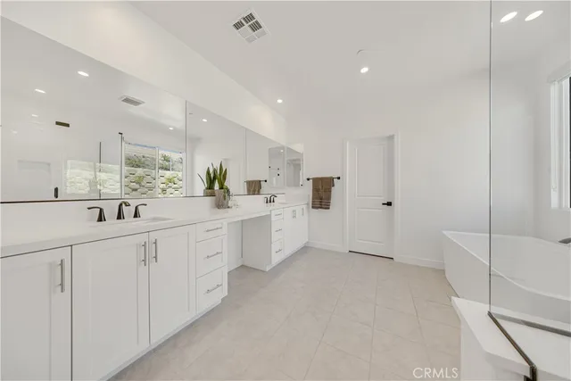 a large white room with white cabinets and sink