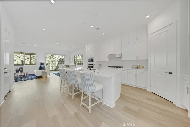 a kitchen with white cabinets and chairs