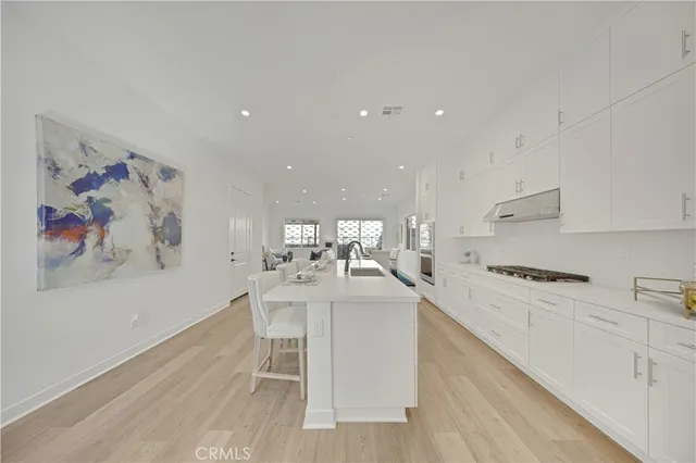 a kitchen with a sink cabinets and wooden floor