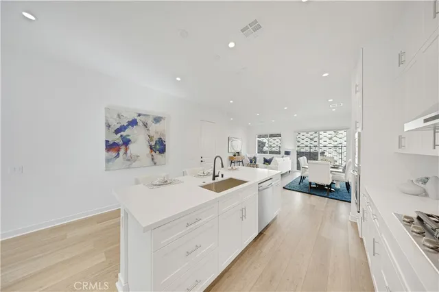 a view of a sink and dishwasher with wooden floor