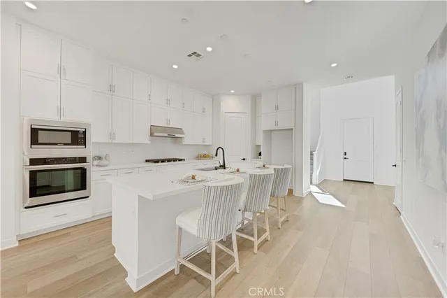 a kitchen with stainless steel appliances a stove a sink and a refrigerator