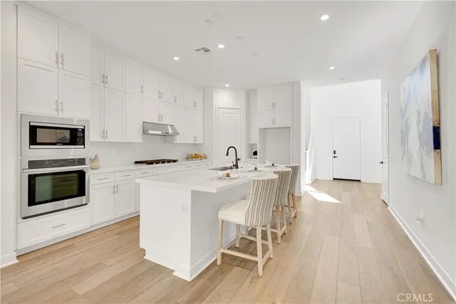 a kitchen with stainless steel appliances a stove a sink and a refrigerator