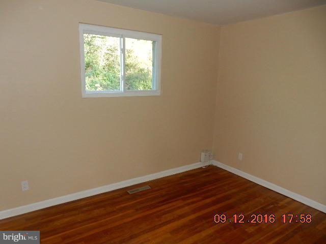 3907 Chaffey Road Randallstown, MD 21133 - Photo 11 of 17 a view of an empty room with wooden floor and a window