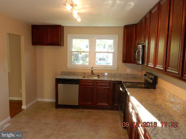 3907 Chaffey Road Randallstown, MD 21133 - Photo 7 of 17 a kitchen with granite countertop a sink stove and cabinets