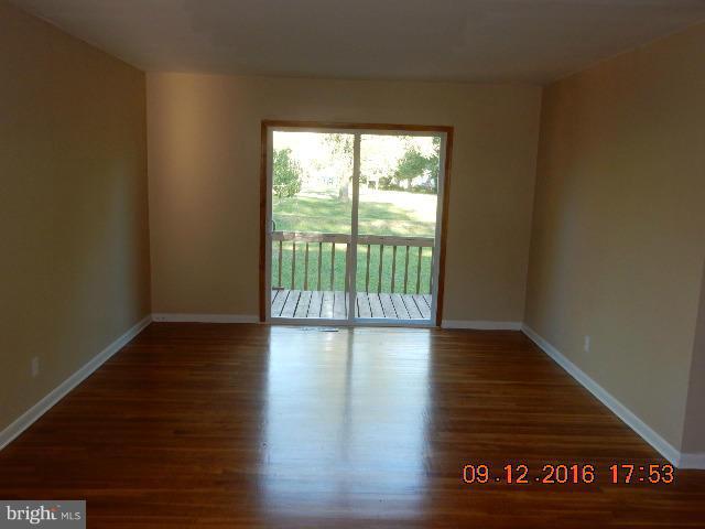 3907 Chaffey Road Randallstown, MD 21133 - Photo 8 of 17 a view of an empty room with wooden floor and a window