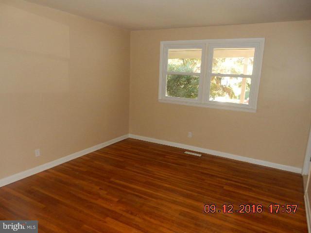 3907 Chaffey Road Randallstown, MD 21133 - Photo 10 of 17 an empty room with wooden floor and windows