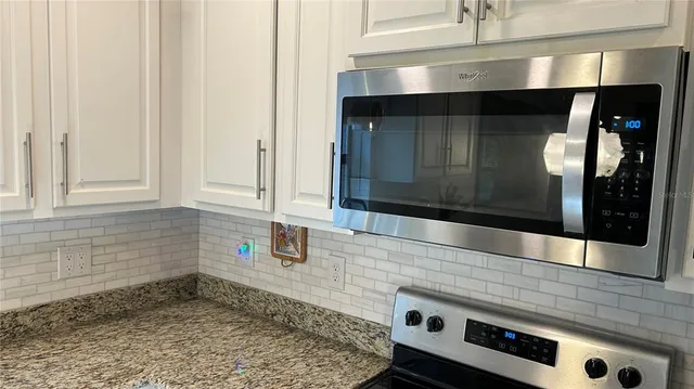 a kitchen with stainless steel appliances granite countertop a sink and cabinets