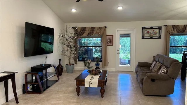 a kitchen with stainless steel appliances granite countertop a refrigerator a stove a sink a dining table and chairs