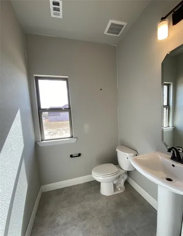 a bathroom with a toilet a sink and a window