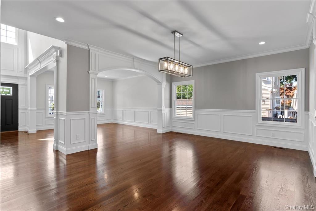 17 Hannington Avenue Wantagh, NY 11793 - Photo 8 of 29 Unfurnished dining area featuring plenty of natural light, arched walkways, ornamental molding, dark wood-style floors, and recessed lighting