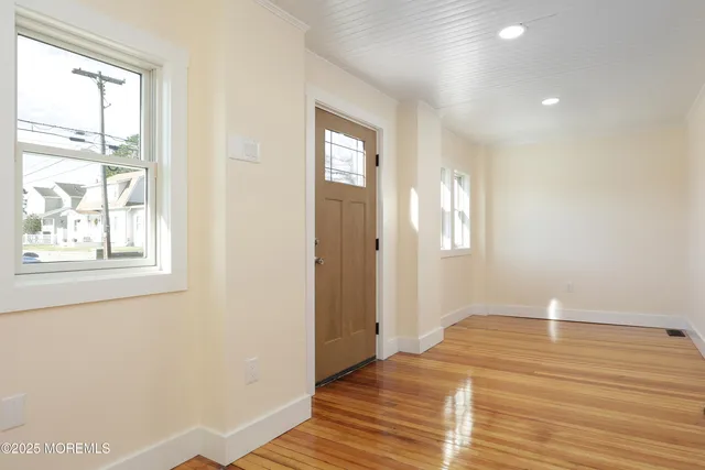 a view of a room with wooden floor and entryway