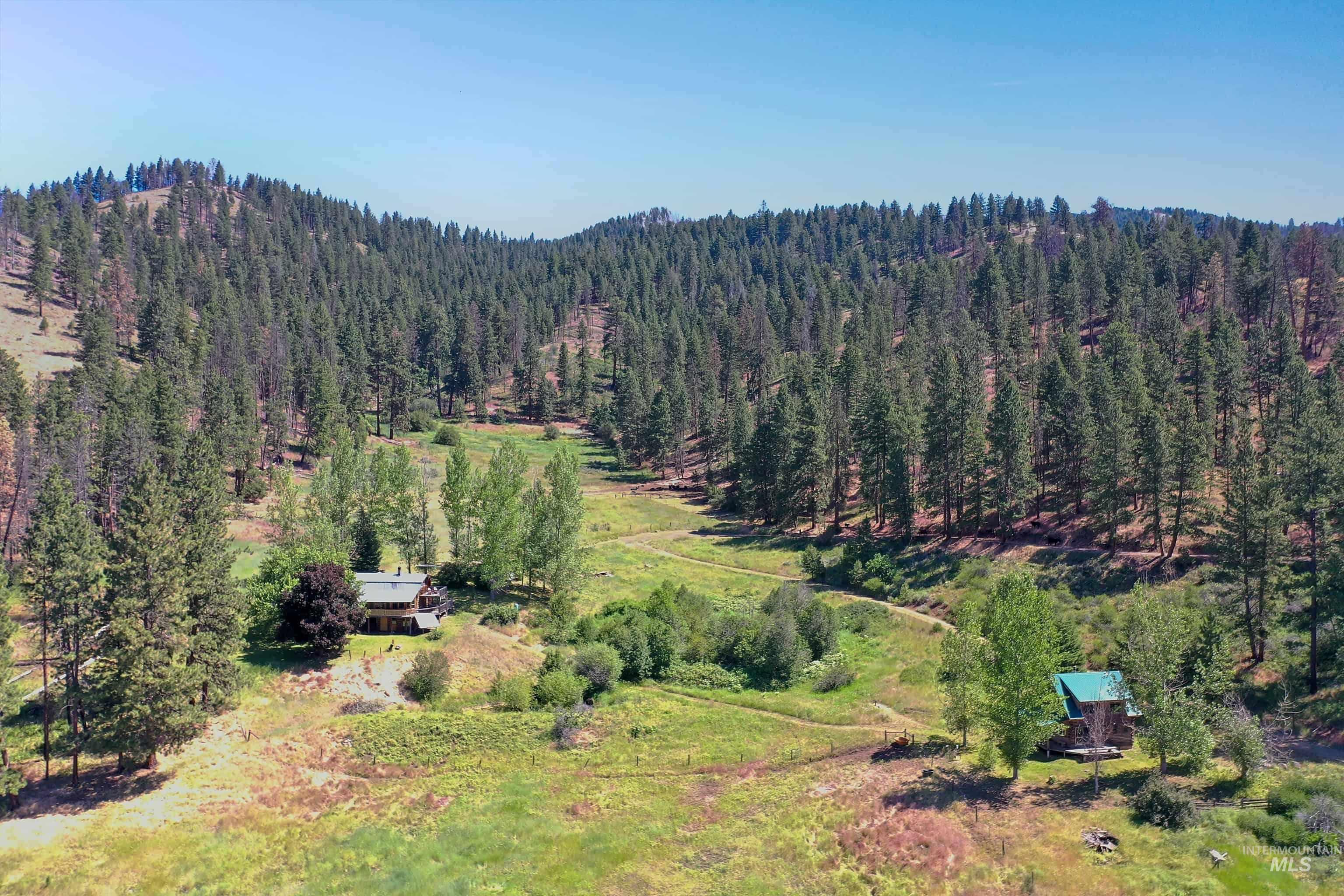 2150 Seid Creek Road Cambridge, ID 83610 - Photo 50 of 50 Expansive property featuring two distinct structures nestled within a verdant, forested landscape