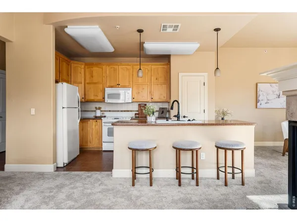 a kitchen island with stainless steel appliances kitchen island granite countertop a stove and a view of living room