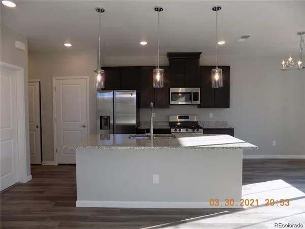 a view of a kitchen with kitchen island a counter top space cabinets and stainless steel appliances