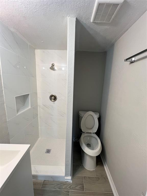 a bathroom with a granite countertop toilet a sink and shower