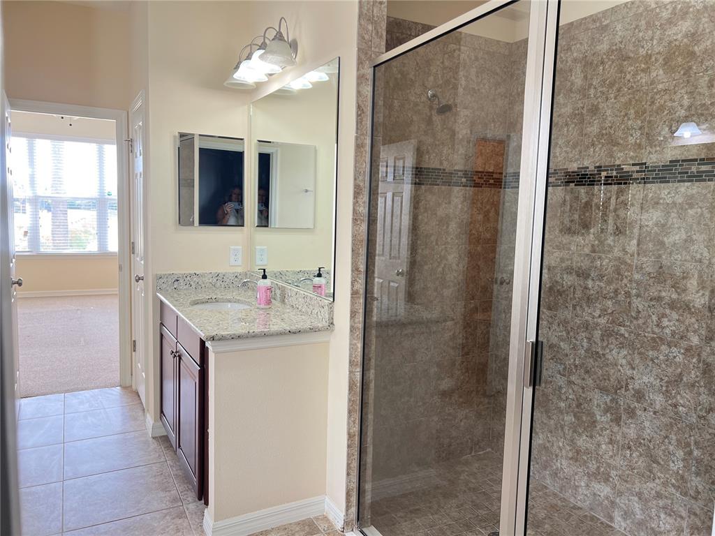5753 Hydrangea Circle Sarasota, FL 34238 - Photo 16 of 31 a bathroom with a granite countertop shower sink and mirror