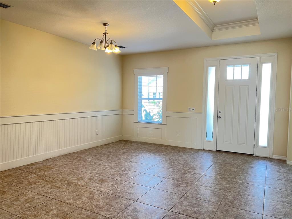 5753 Hydrangea Circle Sarasota, FL 34238 - Photo 4 of 31 an empty room with wooden floor chandelier and windows