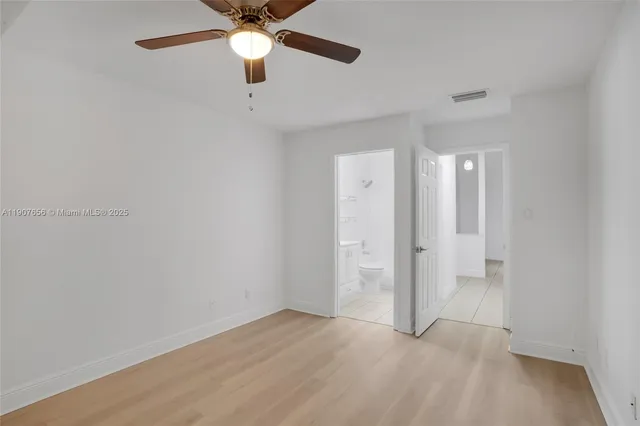 an empty room with closet and a chandelier fan