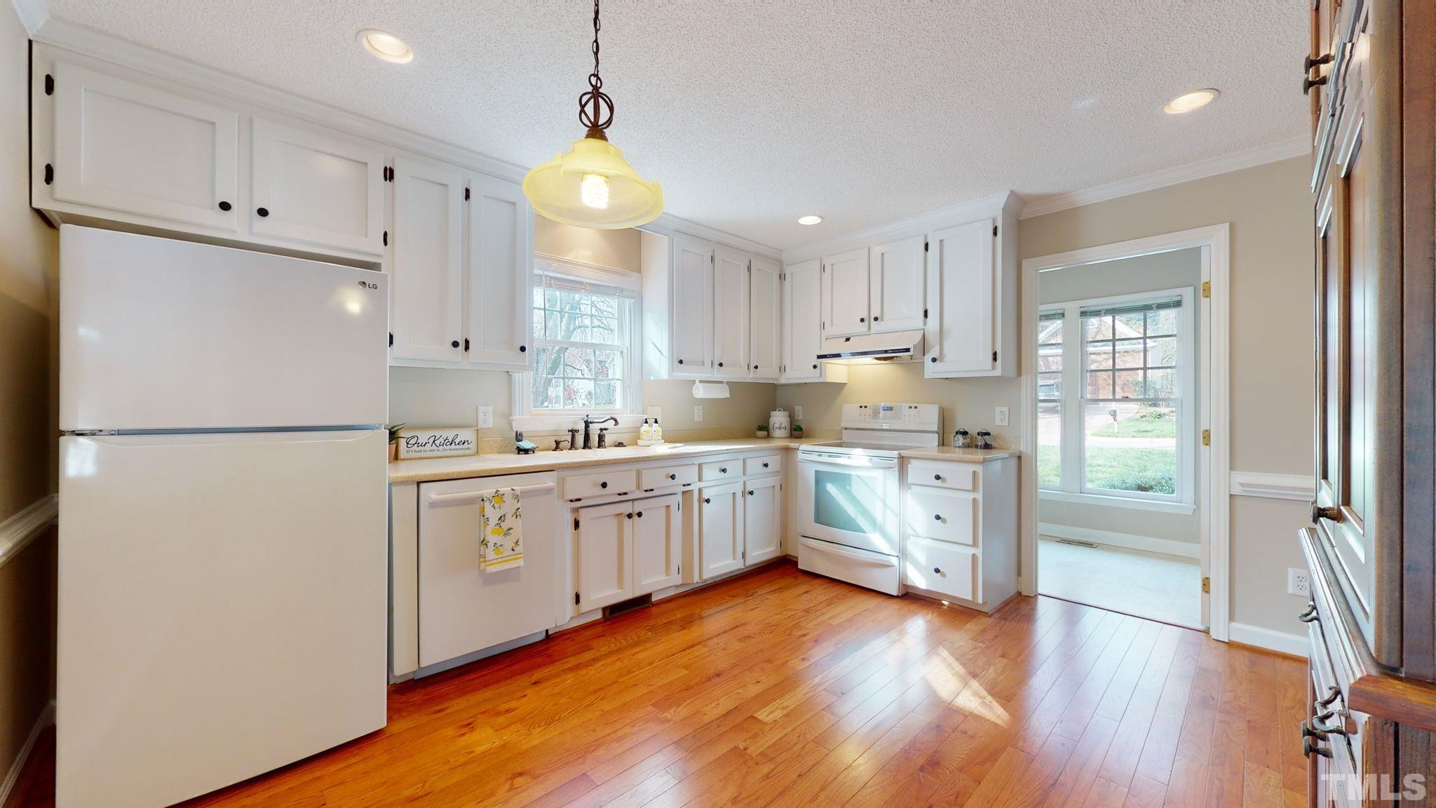 213 Silvercliff Trail Cary, NC 27513 - Photo 7 of 31 a kitchen with white cabinets and white appliances