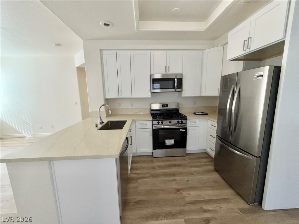 9729 Trail Rider Drive Las Vegas, NV 89117 - Photo 7 of 26 A contemporary kitchen showcasing light-toned countertops and sleek stainless steel appliances.