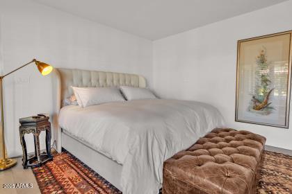 7614 East Gila Bend Road Scottsdale, AZ 85258 - Photo 13 of 36 a bedroom with a bed and a painting on the wall