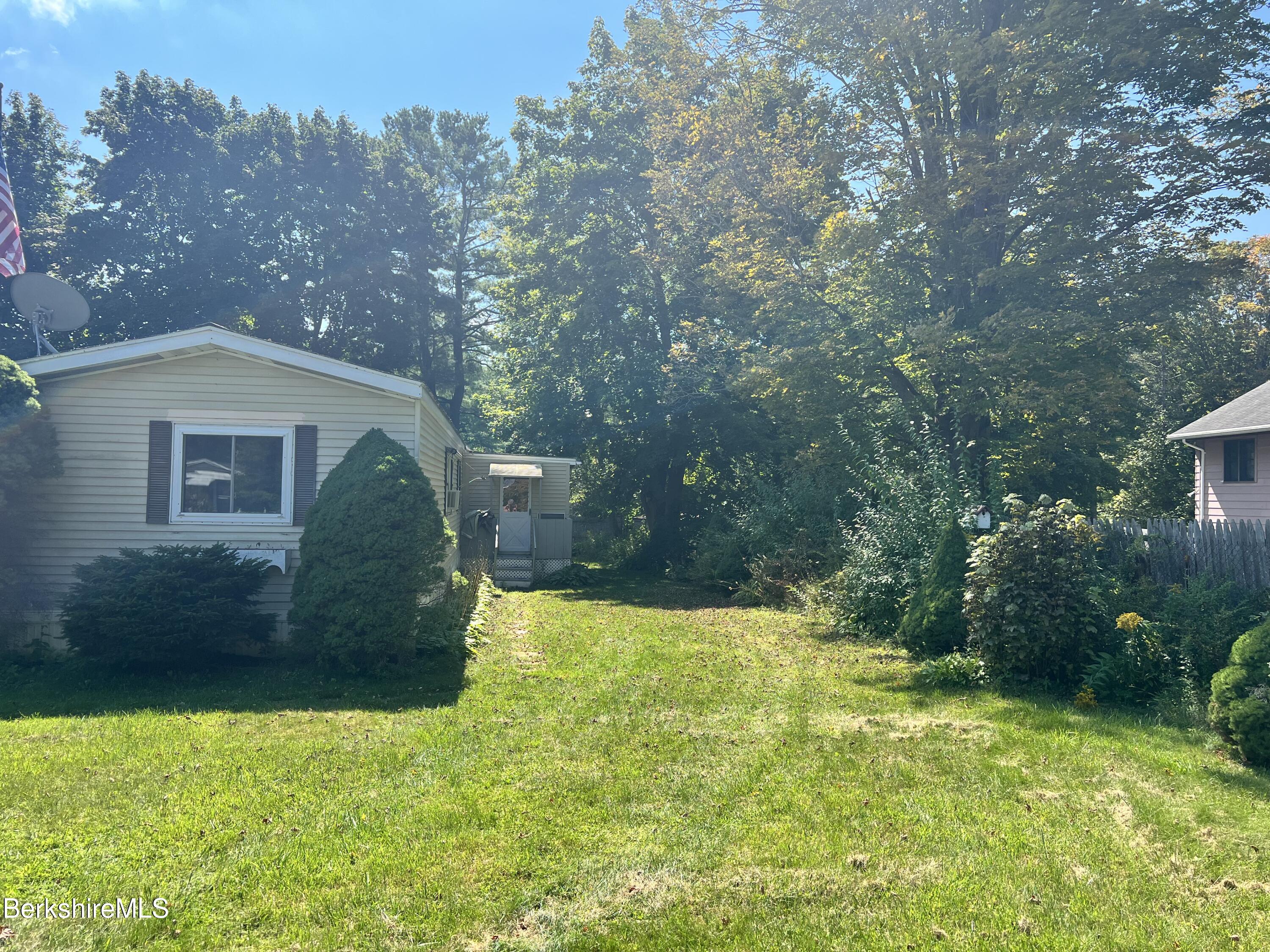 405 Pittsfield Road, Unit H12 Lenox, MA 01240 - Photo 13 of 13 a backyard of a house with lots of green space and fountain