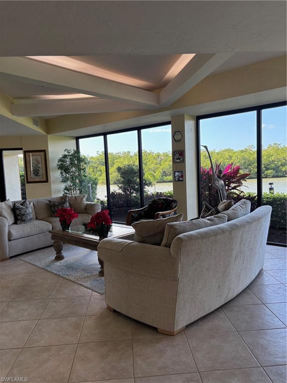 15 Bluebill Avenue, Unit 1006 Naples, FL 34108 - Photo 21 of 25 Living area with light tile patterned floors, healthy amount of natural light, and beam ceiling