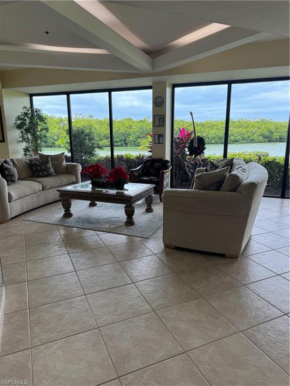 15 Bluebill Avenue, Unit 1006 Naples, FL 34108 - Photo 22 of 25 Living area with light tile patterned floors, beam ceiling, and a water view