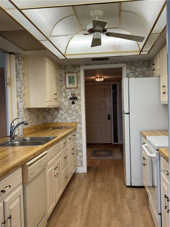 15 Bluebill Avenue, Unit 1006 Naples, FL 34108 - Photo 10 of 25 Kitchen with white range oven, dishwasher, a ceiling fan, white cabinetry, and light wood-style flooring