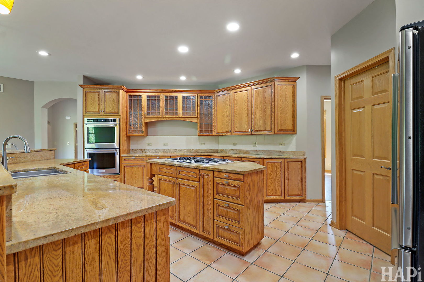 9014 Glacier Ridge Richmond, IL 60071 - Photo 19 of 48 a kitchen with kitchen island granite countertop a sink stove and cabinets