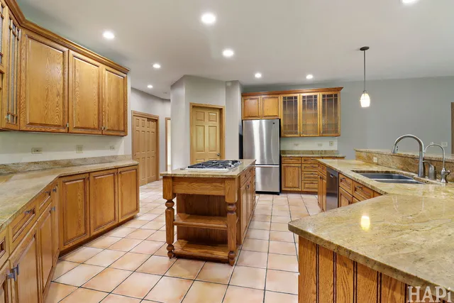 a kitchen with stainless steel appliances granite countertop a sink and a refrigerator