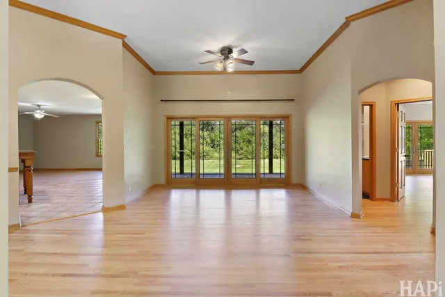 a view of a hallway with wooden floor and a chandelier