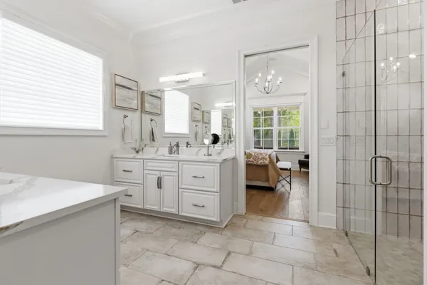 a spacious bathroom with a double vanity sink a mirror and a shower