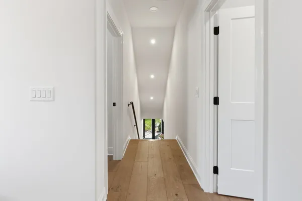 a view of a hallway with wooden floor and staircase