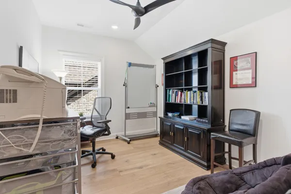 a view of a workspace with furniture and a window