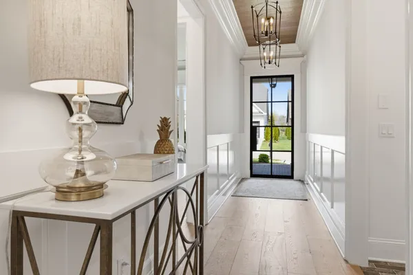 a view of a hallway with couches and chandelier