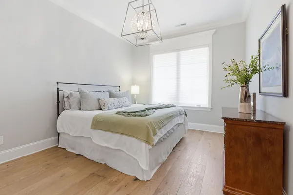 a bedroom with a large bed and a chandelier