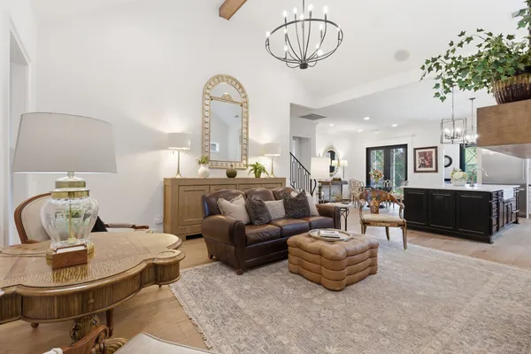 a living room with furniture a chandelier and a table