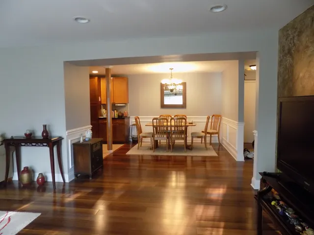 a view of a living room with dining room and wooden floor