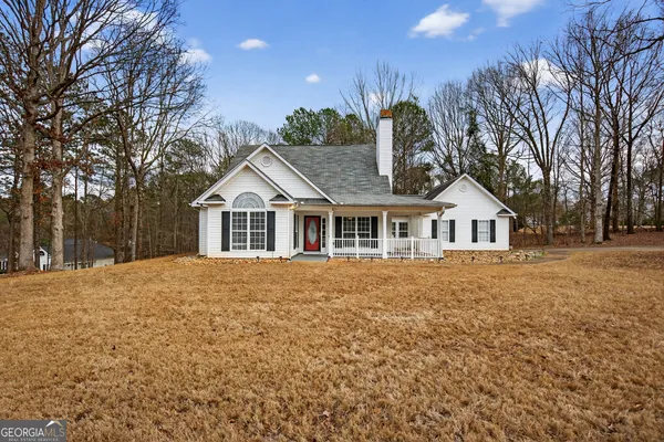 a front of a house with yard and trees