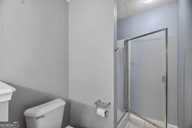 a white toilet sitting next to a shower