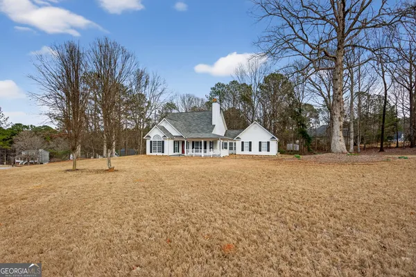 a front view of a house with a yard and trees