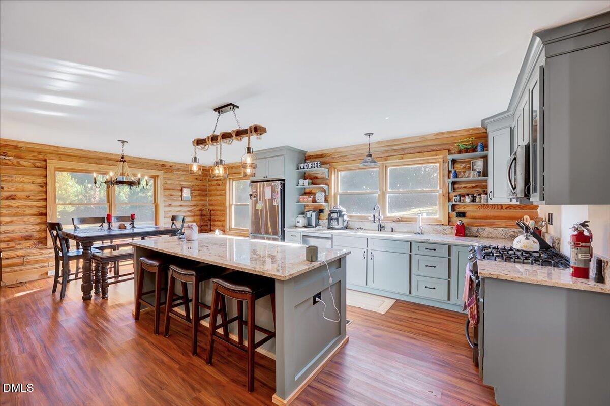8545 Grassy Creek Road Oxford, NC 27565 - Photo 3 of 39 a kitchen with a counter top space a sink wooden floor and stainless steel appliances