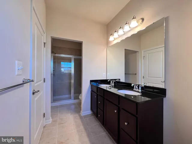 a spacious bathroom with a granite countertop sink and a mirror