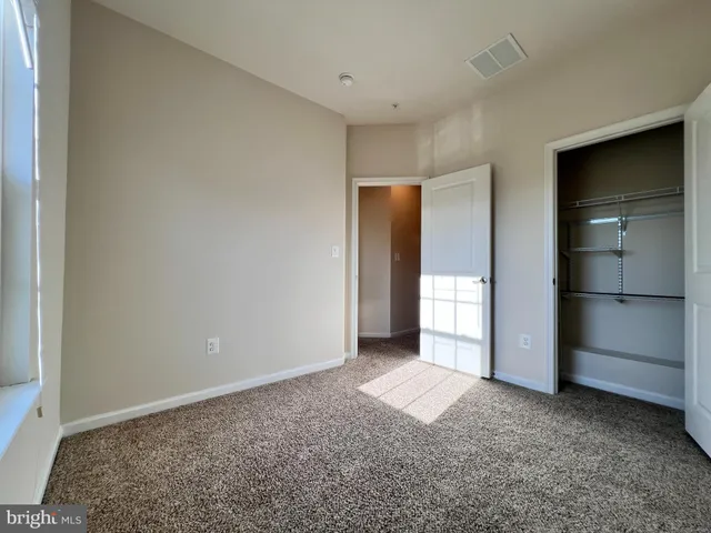a view of an empty room with a kitchen