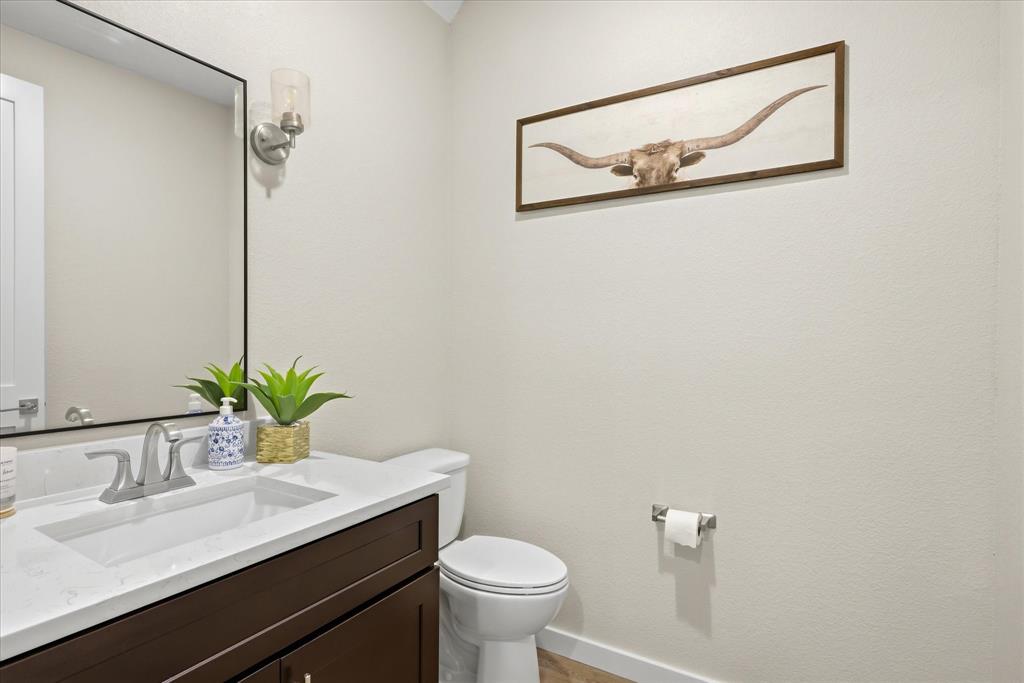 138 Clark Stephenville, TX 76401 - Photo 7 of 32 a bathroom with a sink a toilet and a mirror
