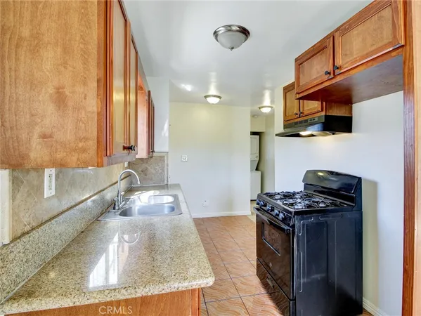 a kitchen with stainless steel appliances granite countertop a sink and a refrigerator