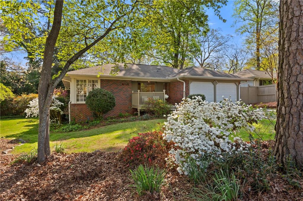 a view of a house with a yard and potted plants