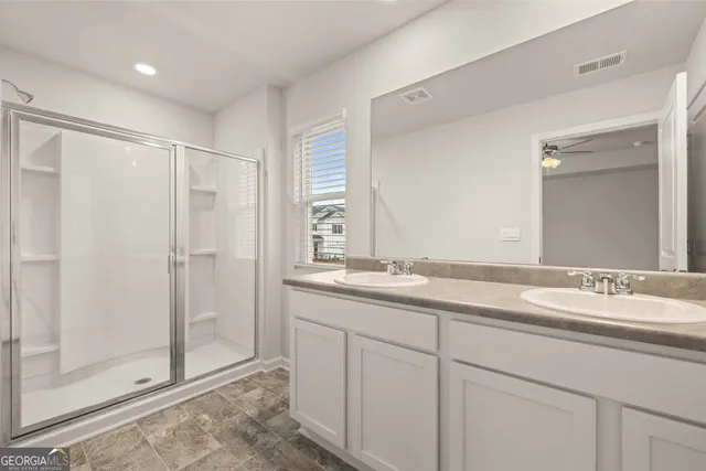 a bathroom with a granite countertop sink a mirror and a shower