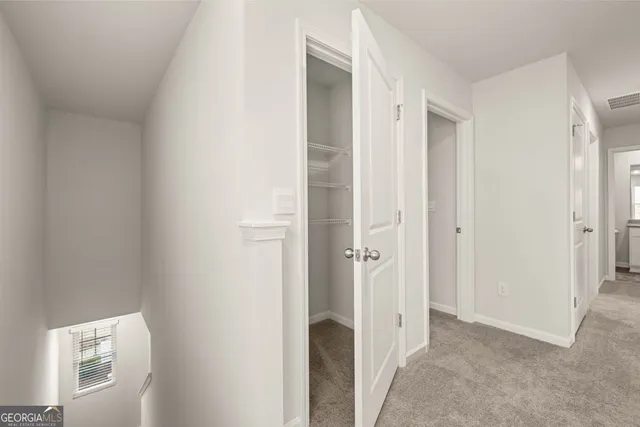 a view of a hallway with a wooden cabinets